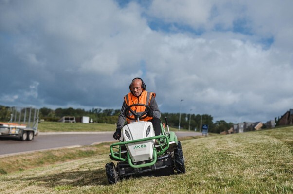 Grounds maintenance schedule being carried out with a ride-on mower across a managed outdoor estate.