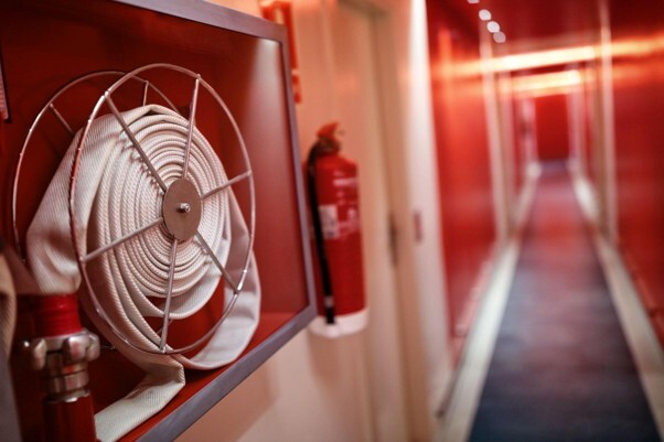 What is fire compartmentation, illustrated by a fire hose reel and fire extinguisher in a protected building corridor.